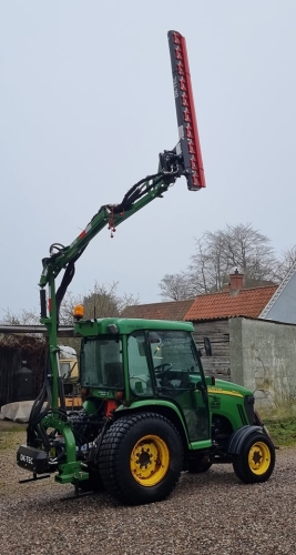 Traktor med værktøj til hækklipning